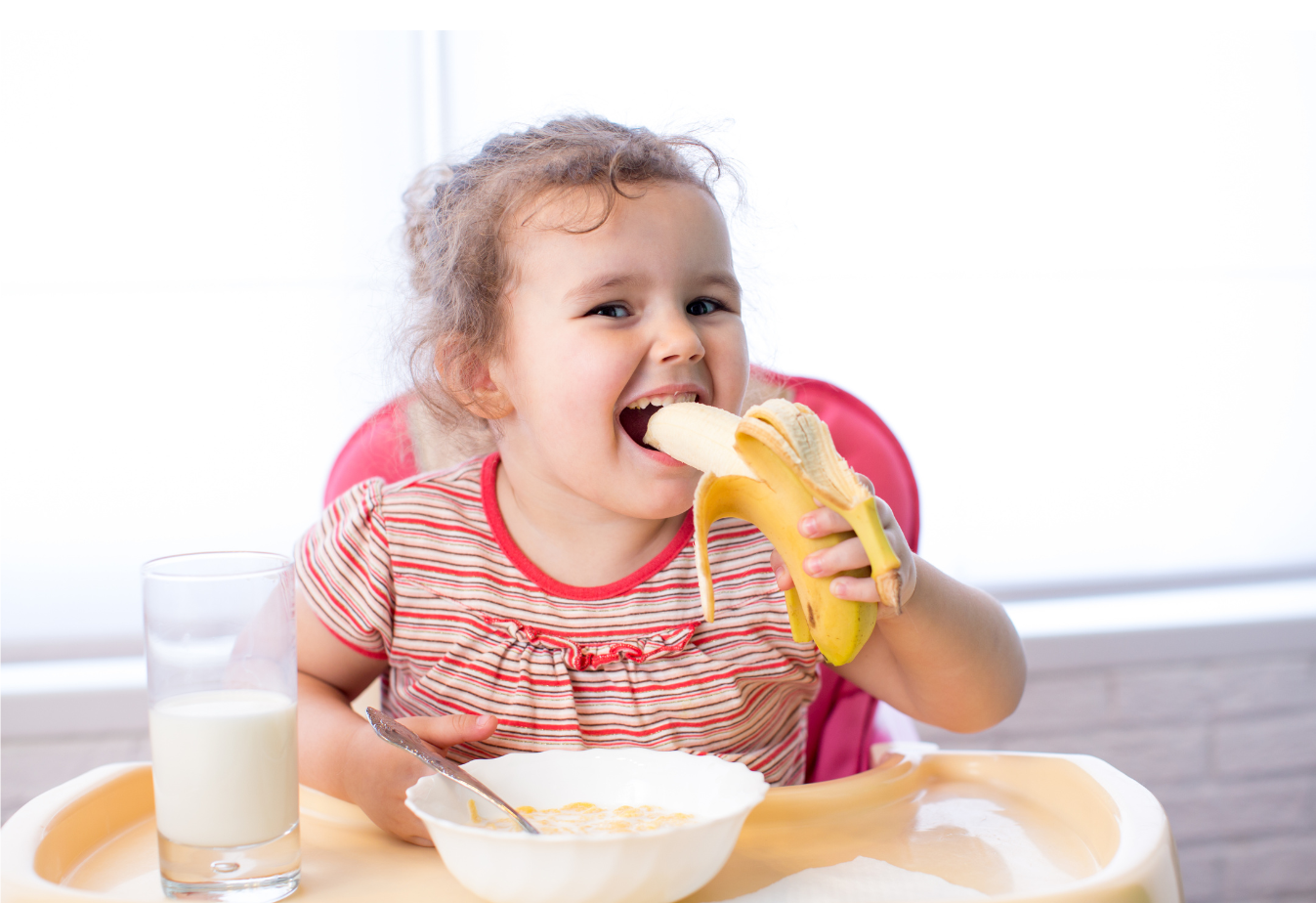 stock photo of young girl eating a banana