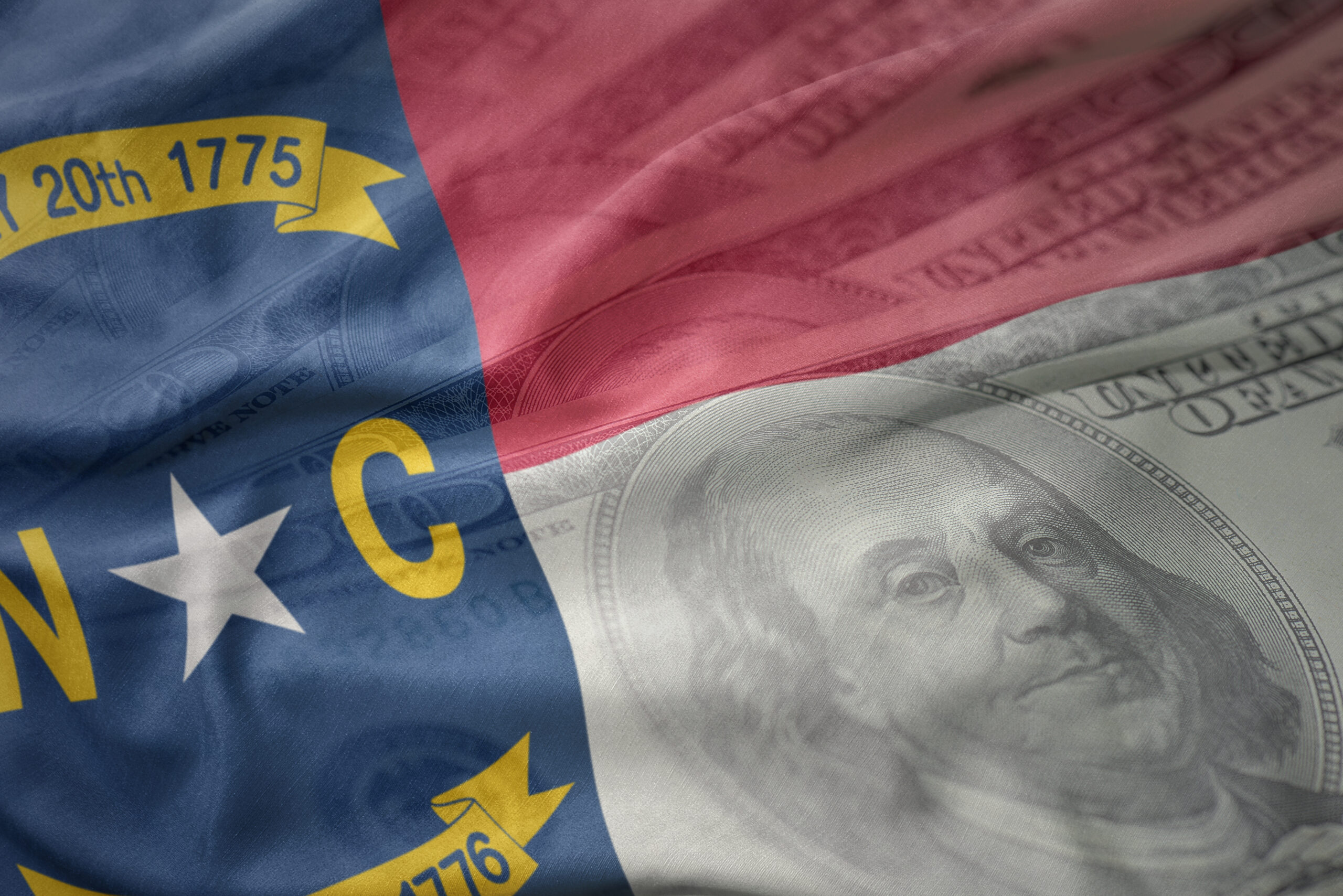 colorful waving flag of north carolina state on a american dollar money background. finance concept