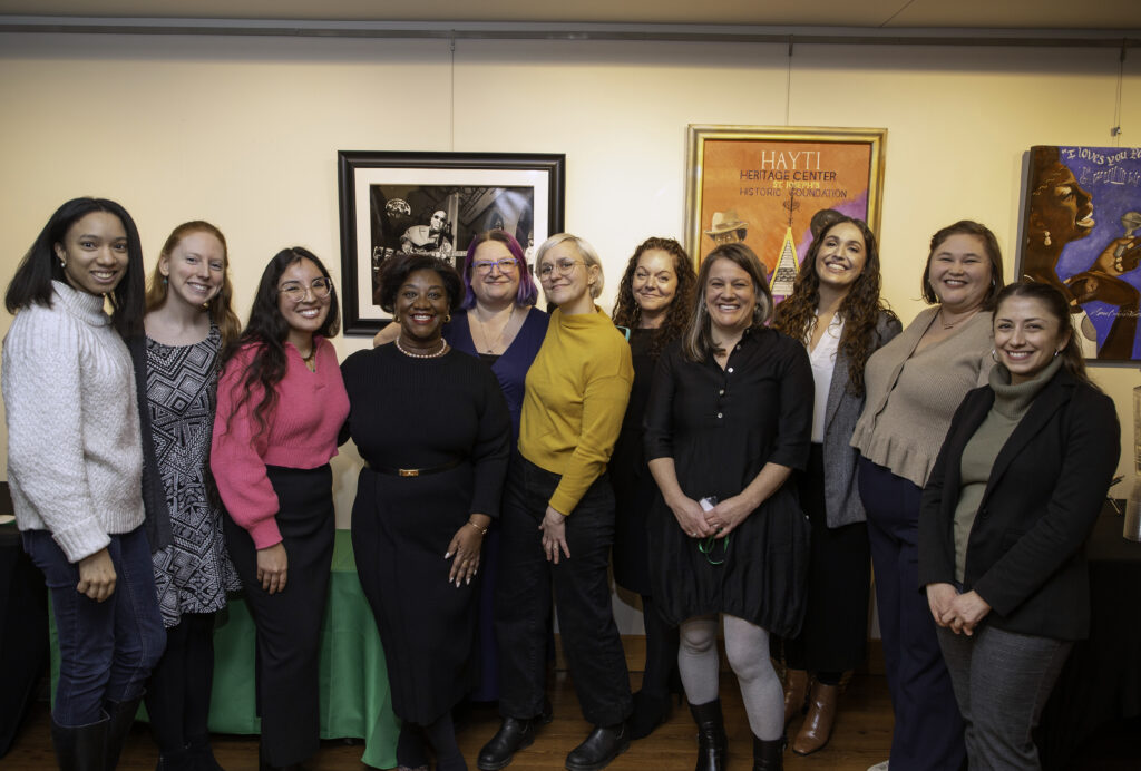 10 members of the Budget & Tax Center team pose with Dr. Tressie McMillan Cottom at an event