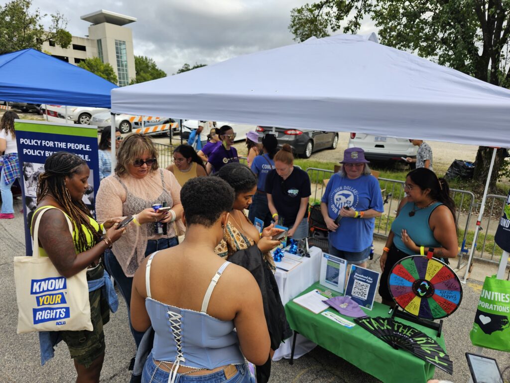 BTC staff members talk with voters at a booth at the Carolina Daze festival.